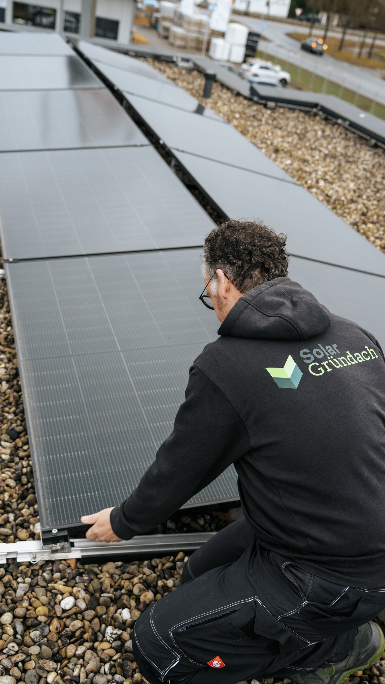 Monteur prüft Solarmodule auf dem Flachdach