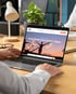 Ein geöffneter grauer Laptop zeigt eine Website mit der Überschrift „We are an award-winning agency dedicated to helping you find your dream home“.