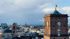Blick über Karlsruhe mit Ziegeltürmen und Kuppeldächern unter einem blauen Himmel.