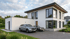 Modernes zweistöckiges Einfamilienhaus in Weiß mit Flachdach, großen Fensterfronten und zwei Autos in der Einfahrt.