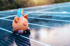 Ein Sparschwein mit Geldscheinen auf einem Solarmodul liegend.