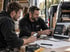 Handwerker besprechen gemeinsam einen digitalen Betriebsauftritt am Laptop