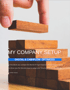 Hand placing a wooden block on a stack of blocks forming steps. Text: MY COMPANY SETUP.