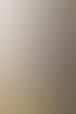 Ein Maler auf einer Holzleiter trägt Spachtelmasse auf eine lila Wand auf.