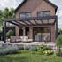 Moderne Terrasse mit grauer Pergola, Gartenmöbeln und Ziegelhaus.