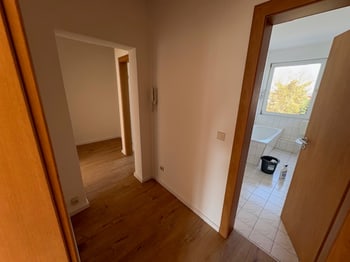 Flur mit Blick durch die offene Tür in das gefliestes Bad