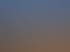 Weite Sanddünen der Sahara unter strahlender Sonne und klarem blauem Himmel mit feinen Wellenmustern im Wüstensand.