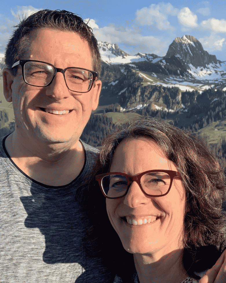 Patrick Andreas Näf mit seiner Partnerin Manuela, beide lachend, vor einer Berglandschaft