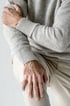 A close-up of a person's hands holding their painful wrist.