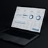 Laptop zeigt ein Dashboard mit Diagrammen, Grafiken und Zahlen auf dunklem Hintergrund.