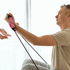 Man using a pink resistance band to rehabilitate.
