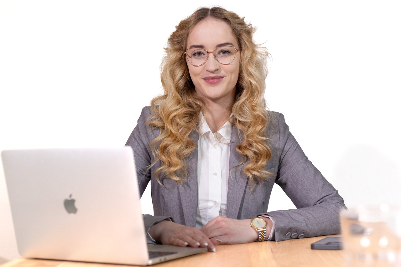 Unternehmerin sitzt an einem Schreibtisch, vor ihr ein Laptop. 