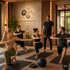 Vier Personen machen Ausfallschritte auf Yogamatten, ein Trainer steht daneben. Logo "ELEMENTS LONGEVITY & BIOHACKING".
