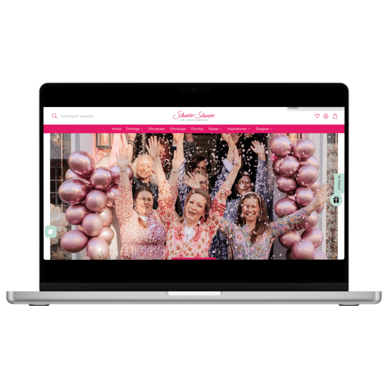 Laptop zeigt die Startseite von "SchwesterSchwester.de" mit jubelnden Frauen und rosafarbenen Ballons.
