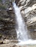 Wasserfall fällt von einer felsigen Klippe in einen Pool.