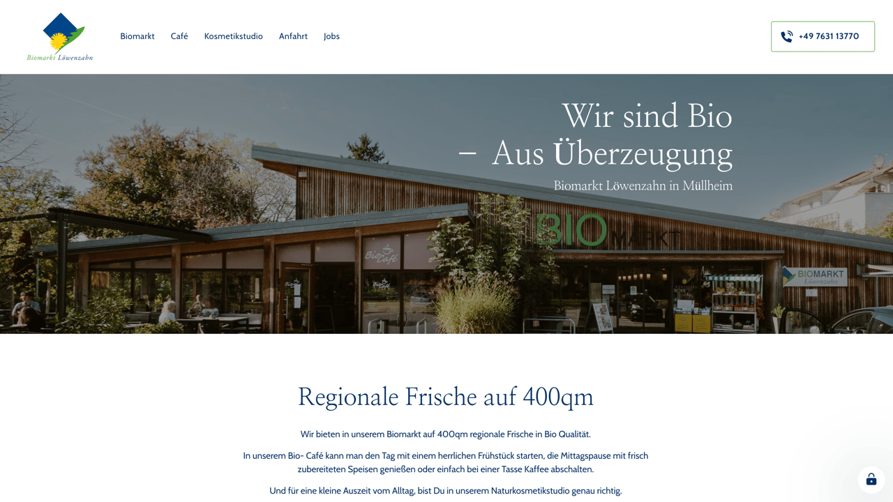 Moderne Holzfassade eines Biomarkts mit Text "Wir sind Bio, Aus Überzeugung" und "BIO" Logo.