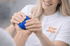 Ergotherapeutin von ErgoPlus trainiert mit einer Patientin die Handkraft mit einem blauen Therapieball
