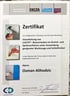 Hand hält weißen Stylus über dem Bildschirm eines silbernen Tablets.