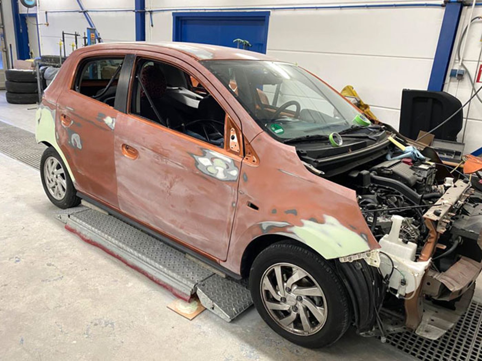 Kleinwagen in der Unfallinstandsetzung, Front zerlegt und Karosserie zur Lackvorbereitung geschliffen