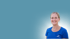 Lächelnde blonde Frau in blauem Poloshirt sitzt am Steuer eines weißen Lieferwagens.
