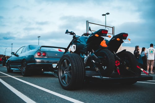 Two motorcycles strapped upright on a trailer, showing how a motorcycle is secured for towing in Corona, CA