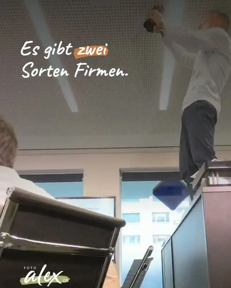 Alex steht in einem Zürcher Büro auf einem Sideboard und fotografiert mit der Kamera nach unten, im Vordergrund Bürostühle und eine Mitarbeiterin von hinten. Darauf der Text «Es gibt zwei Sorten Firmen.»