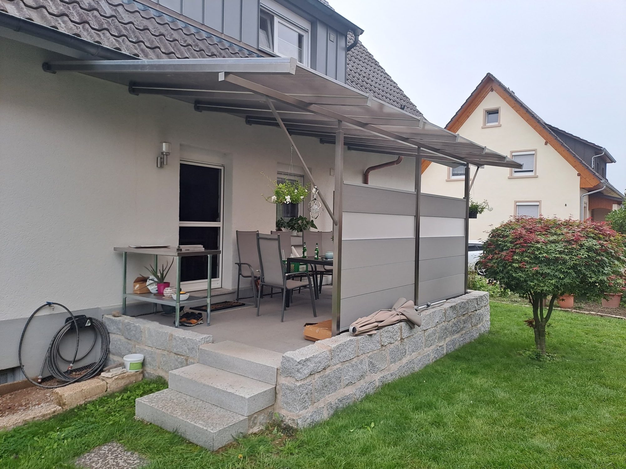Terrassenüberdachung aus Edelstahl mit Polycarbonat-Dach und Sichtschutzwand