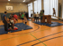 Kinder und Erwachsene spielen in einer Turnhalle mit Matten und Holzgeräten.