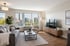 Modernes Wohnzimmer mit grauem Sofa, Holzmöbeln und großem Fenster mit Blick auf die Stadt.