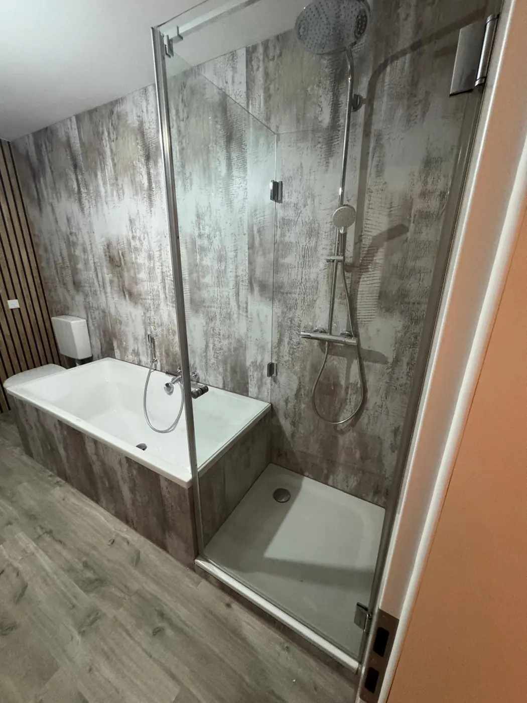 Fertiges Bad mit Wanne, Dusche und verkleideten Wänden