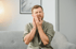 Man holding jaw in pain, illustrating TMJ disorder treatment focus.