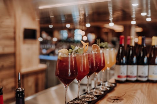 Fünf Cocktails in Gläsern mit Zitrus und Minze auf einer Holztheke