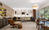 Mid-century modern living room with a cream sofa, Eames lounge chair, and large windows.