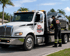 Towing Deltona flatbed towing service securing a sedan onto a rollback truck for safe vehicle transport