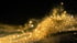 Goldglitzerstaub schwebt und funkelt auf einem schwarzen Hintergrund.