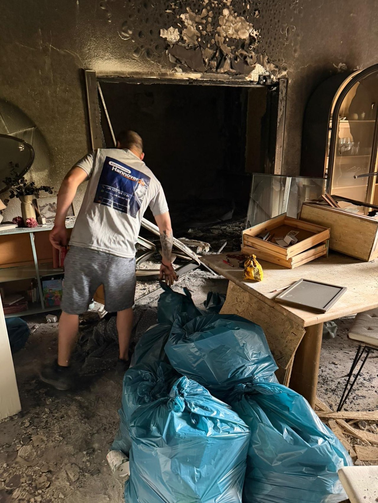 Mitarbeiter bei einer Räumung, von hinten, mit Firmenbranding auf der Arbeitskleidung