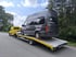 Dunkelgrauer Campervan "Freeway Camper" wird auf gelbem Abschleppwagen transportiert.