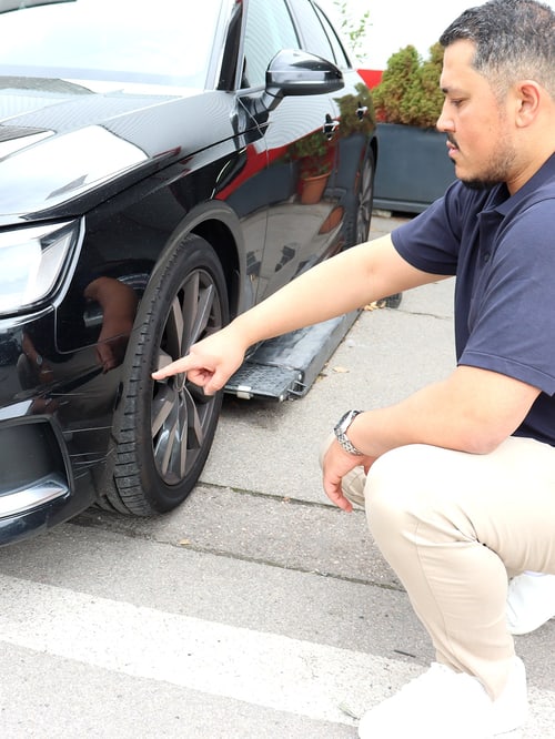 KFZ-Gutachter Jawid Rahimi dokumentiert einen Unfallschaden am Radlauf eines Fahrzeugs in München