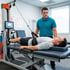 Man on a spinal decompression therapy table with a therapist standing by him.