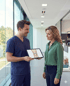 Ein Arzt zeigt einer Patientin eine Kniegelenk-Darstellung auf einem Tablet.