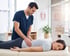 Healthcare provider performing a hands-on physical rehabilitation assessment on a patient’s lower back.