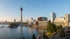 Düsseldorfer Medienhafen mit Rheinturm, Gehry-Bauten und Hafenbecken bei sonnigem Wetter.