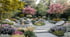 Großer Garten mit Steinplattenweg, Feuerstelle, Wasserfall, blühenden Bäumen und Blumen.