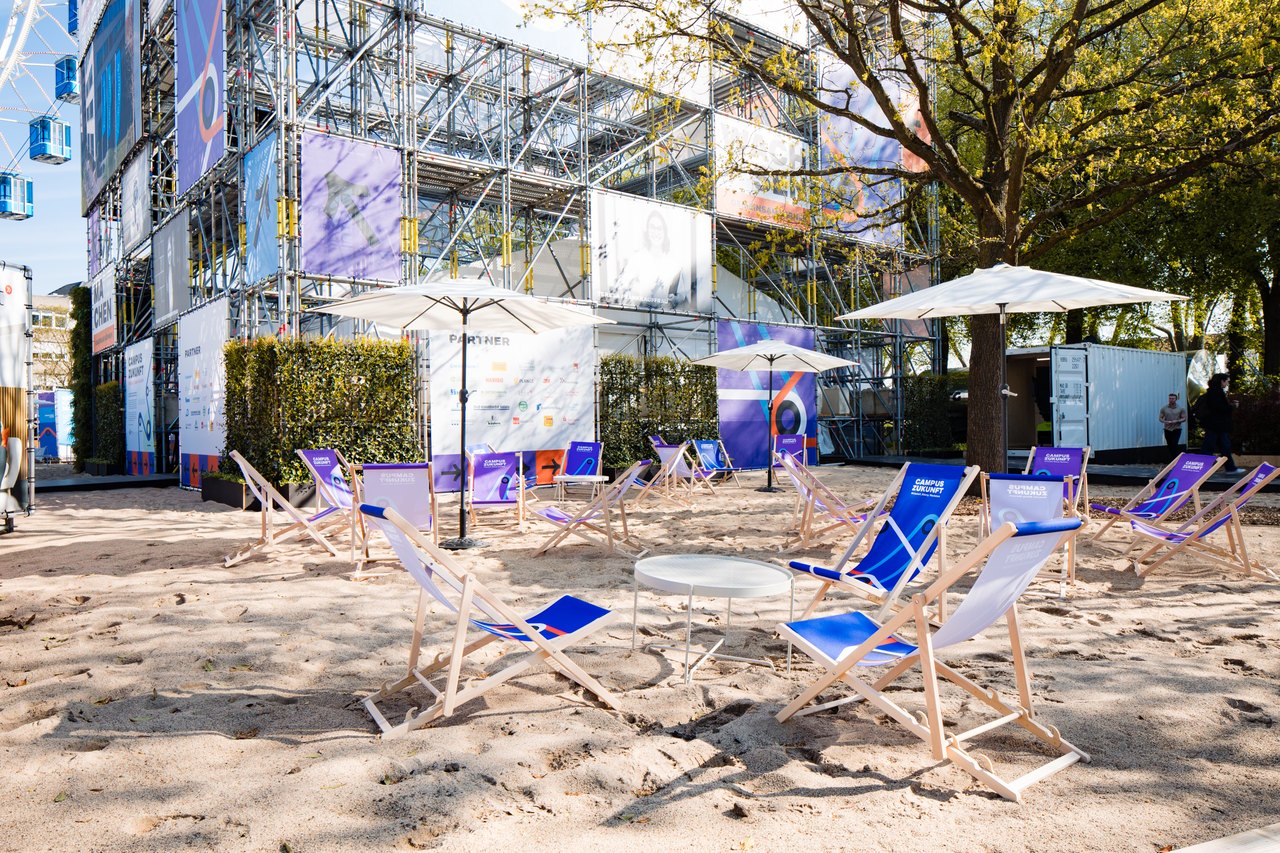 Die Outdoor-Lounge mit Liegestühlen und Sonnenschirmen – ein Treffpunkt für Networking und Gespräche im Freien