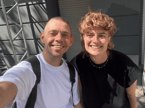 A man and a woman smile into the camera.