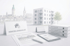 Immobilienmakler-Schreibtisch mit Exposé, Tablet und Aktenordnern vor einem modernen Wohnhaus und Stadtpanorama.