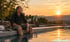 Ein Mann sitzt am Rand eines Pools bei Sonnenuntergang, im Hintergrund steht ein Bagger auf einer Baustelle.