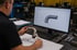 Mitarbeiter vergleicht CAD-Zeichnung und Rohrkomponente zur technischen Machbarkeitsprüfung.