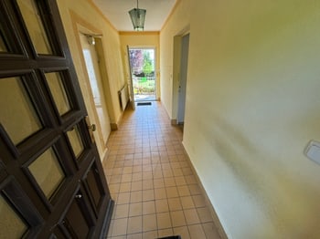 Hausflur mit Fliesenboden und Blick durch die Terrassentür in den Garten
