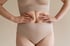 Woman holding abdomen showing muscle separation